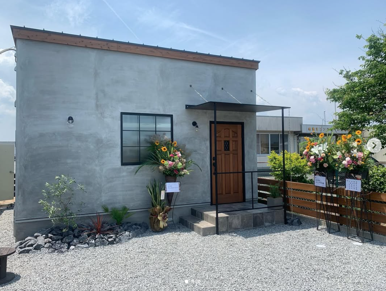 グレーの外壁と木製ドアが印象的な住宅外観の施工実績
